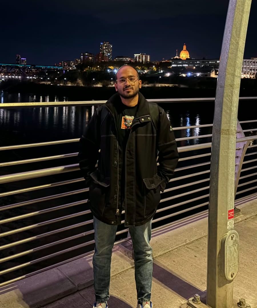 Karthikeyan Umesh standing on a bridge at night, with the 17 body points the pose model found drawn over the photo in yellow.